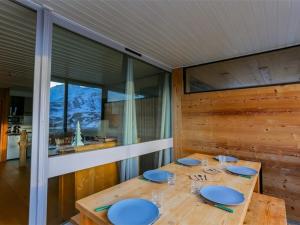 une salle à manger avec une table en bois avec des assiettes bleues dans l'établissement Appartement rénové montagne à Val Thorens - 6 pers, 34 m², Veranda, Ski In/Out, WIFI - FR-1-637-6, à Val Thorens 7 autres photos