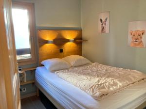 a bedroom with a bed with a headboard and a window at Appartement Avoriaz, 2 pièces, 4 personnes - FR-1-634-48 in Avoriaz