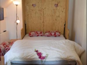 1 dormitorio con cama blanca y almohadas rojas en Studio Montgenèvre, 2 pièces, 4 personnes - FR-1-266-170, en Montgenèvre