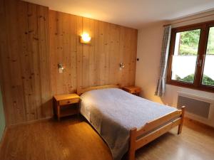 um quarto com uma cama com paredes de madeira e uma janela em Appartement Arêches-Beaufort, 3 pièces, 4 personnes - FR-1-342-236 em Beaufort