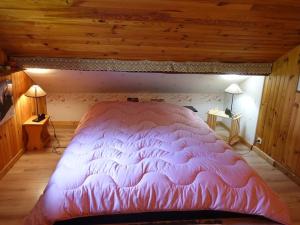 ein großes rosa Bett in einem Zimmer mit Holzdecken in der Unterkunft Chalet Arêches-Beaufort, 4 pièces, 10 personnes - FR-1-342-224 in Beaufort
