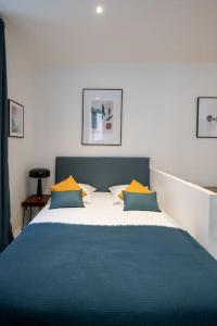 um quarto com uma cama com almofadas azuis e amarelas em Opéra 8 - Superbe studio refait à neuf proche place des Terreaux em Lyon