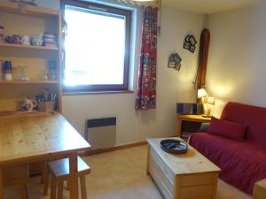 a living room with a red couch and a window at Studio Arêches-Beaufort, 1 pièce, 3 personnes - FR-1-342-253 in Beaufort