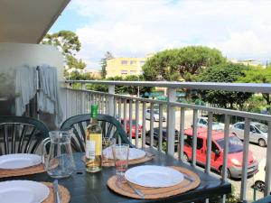 un tavolo con piatti e bicchieri da vino su un balcone di Appartement Cagnes-sur-Mer, 1 pièce, 4 personnes - FR-1-252A-56 a Cagnes-sur-Mer