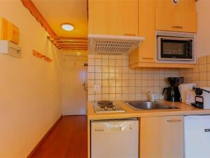 a small kitchen with a sink and a microwave at Charmant Appartement Rénové - 4 Pers, Balcon Sud, Cœur de Val Thorens, Accès Pistes et Commerces - FR-1-637-7 in Val Thorens