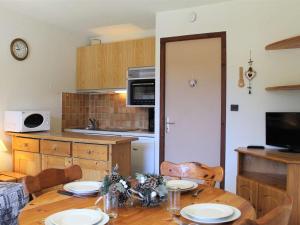 una cucina con tavolo in legno e piatti di Studio Montagne 4 Pers. à Vars Les Claux - Pied des Pistes, proche Commerces et École de Ski - FR-1-330B-178 a Vars