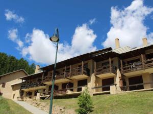 un edificio con balconi e un lampione di Studio Montagne 4 Pers. à Vars Les Claux - Pied des Pistes, proche Commerces et École de Ski - FR-1-330B-178 a Vars