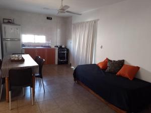 a bedroom with a bed and a table and a kitchen at Villa Aurora in Potrero de Garay