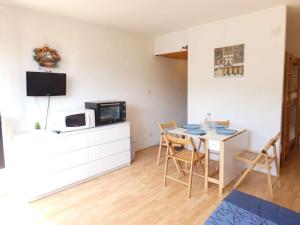 a kitchen and dining room with a table and a tv at Studio Piau-Engaly, 1 pièce, 4 personnes - FR-1-457-297 in Aragnouet