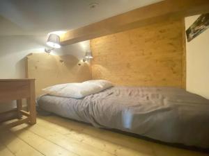 a bedroom with a bed with a wooden wall at Appartement Praz-sur-Arly, 1 pièce, 6 personnes - FR-1-603-47 in Praz-sur-Arly