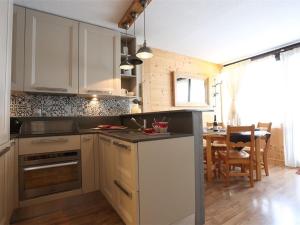 uma cozinha com armários brancos e uma sala de jantar em Appartement Val Thorens, 3 pièces, 5 personnes - FR-1-637-3 em Val Thorens