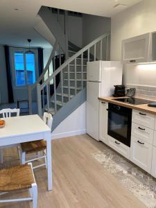 eine Küche mit weißen Schränken und einer Treppe in der Unterkunft Les Beaux Jours, Tours, le Duplex in Tours