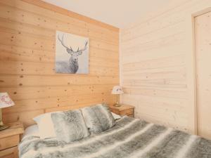 ein Schlafzimmer mit einem Bett und einem Bild eines Hirsches in der Unterkunft Appartement Val Thorens, 3 pièces, 5 personnes - FR-1-637-3 in Val Thorens