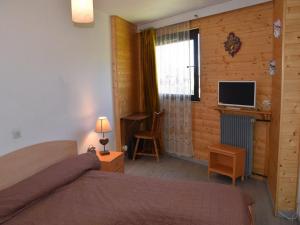 1 dormitorio con 1 cama, TV y ventana en Appartement Montgenèvre, 2 pièces, 6 personnes - FR-1-266-172, en Montgenèvre