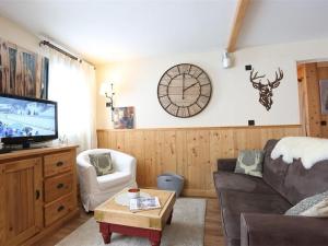 a living room with a couch and a clock on the wall at Appartement Val Thorens, 3 pièces, 5 personnes - FR-1-637-3 in Val Thorens