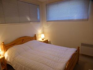 1 Schlafzimmer mit einem weißen Bett und 2 Fenstern in der Unterkunft Appartement Arêches-Beaufort, 3 pièces, 7 personnes - FR-1-342-241 in Beaufort