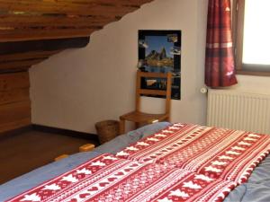 a bedroom with a bed with a red and white blanket at Chalet Arêches-Beaufort, 5 pièces, 8 personnes - FR-1-342-246 in Beaufort