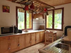 eine Küche mit Holzschränken und einer Mikrowelle in der Unterkunft Chalet Arêches-Beaufort, 5 pièces, 14 personnes - FR-1-342-239 in Beaufort