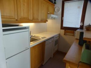 eine kleine Küche mit Holzschränken und einem Waschbecken in der Unterkunft Appartement Arêches-Beaufort, 3 pièces, 7 personnes - FR-1-342-241 in Beaufort