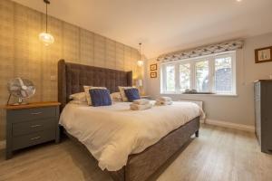 - une chambre avec un grand lit et une fenêtre dans l'établissement The Cowshed at Green Valley Farm, à Laxfield