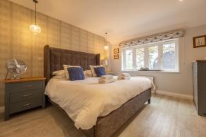 a bedroom with a large bed and a window at The Cowshed at Green Valley Farm in Laxfield