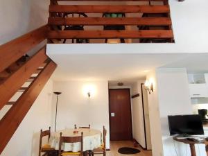 a living room with a table and a wooden staircase at Appartement Cauterets, 3 pièces, 6 personnes - FR-1-234-263 in Cauterets