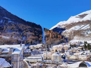 a small town with snow covered buildings and a mountain at Appartement Cauterets, 3 pièces, 6 personnes - FR-1-234-263 in Cauterets