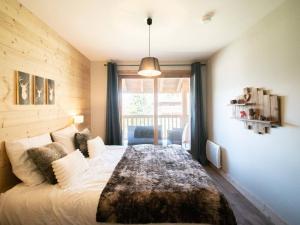 ein Schlafzimmer mit einem großen Bett mit einem großen Fenster in der Unterkunft Duplex 4P à La Charmette, 3 Ch, 8 Pers, Balcon, Parking - FR-1-291-869 in Valmorel