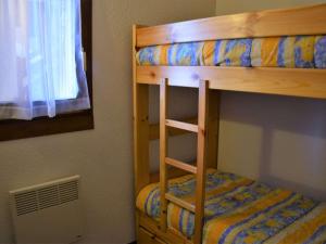 a bunk bed with a ladder next to a window at Appartement Risoul, 1 pièce, 4 personnes - FR-1-330-542 in Risoul