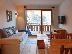 a living room with a couch and a balcony at Appartement Les Orres, 2 pièces, 5 personnes - FR-1-322-452 in Les Orres