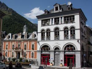 a large white building in front of a mountain at Appartement Cauterets, 3 pièces, 6 personnes - FR-1-401-230 in Cauterets