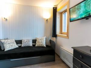 a black couch in a room with a flat screen tv at Appartement Val Thorens, 3 pièces, 4 personnes - FR-1-637-22 in Val Thorens