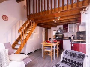 a kitchen and a living room with a table and a staircase at Appartement Saint-Lary-Soulan, 2 pièces, 4 personnes - FR-1-296-359 in Saint-Lary-Soulan