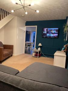 a living room with a couch and a tv on the wall at Manchester 2 Bedroom House with Garden in Manchester