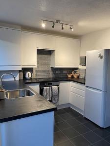 a kitchen with white cabinets and a white refrigerator at Manchester 2 Bedroom House with Garden in Manchester