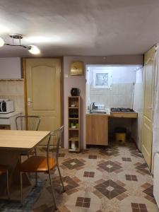 een keuken met een tafel en stoelen en een wastafel bij Carissa House in Braşov