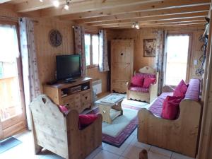 ein Wohnzimmer mit Sofas und einem TV in einer Hütte in der Unterkunft Chalet Le Biot, 6 pièces, 8 personnes - FR-1-573-52 in Le Biot