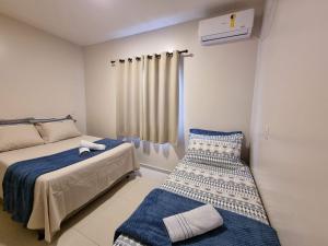 een slaapkamer met 2 bedden, een raam en een nachtkastje bij Curta Praia de Armação Casa Hortênsia in Penha