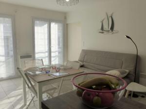 sala de estar con mesa y sofá en Appartement Saint-Gilles-Croix-de-Vie, 2 pièces, 4 personnes - FR-1-224-783, en Saint Gilles Croix de vie