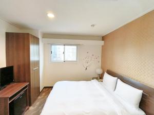 um quarto com uma grande cama branca e uma janela em 信然文旅-首學 寵物友善預訂前務必事先詢問 em Tainan