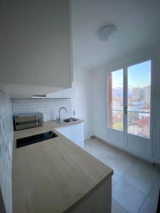 a white kitchen with a sink and a window at Petit cocon avec Balcon au centre de Marseille in Marseille