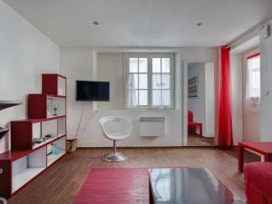 a living room with a couch and a television at Appartement Moderne Centre-ville, à Deux Pas de la Plage ! - FR-1-4-619 in Saint-Jean-de-Luz