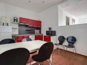 a kitchen with red cabinets and a table and chairs at Appartement Moderne Centre-ville, à Deux Pas de la Plage ! - FR-1-4-619 in Saint-Jean-de-Luz
