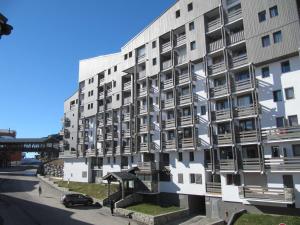 an apartment building with a car parked in front of it at Moderne appartement 4 pers à Val Thorens avec WiFi et balcon - FR-1-637-37 in Val Thorens