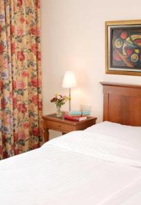 a bedroom with a bed and a table with a lamp at Hotel Deutsches Theater Stadtzentrum in Munich