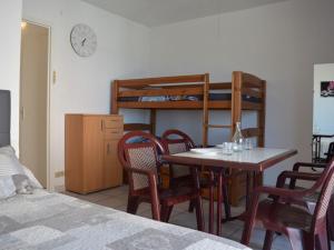 Cette chambre dispose d'une table, de chaises et de lits superposés. dans l'établissement Appartement Saint-Cyprien, 1 pièce, 4 personnes - FR-1-225D-125, à Saint-Cyprien