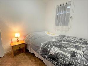 een slaapkamer met een bed en een tafel met een lamp bij Appartement Saint-Cyprien, 2 pièces, 4 personnes - FR-1-225D-131 in Saint-Cyprien