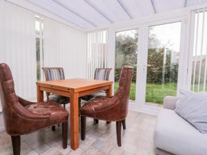 comedor con mesa de madera y sillas en 1 Springfield Road, en Margate