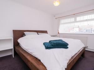 een slaapkamer met een bed met een groene handdoek erop bij 1 Springfield Road in Margate
