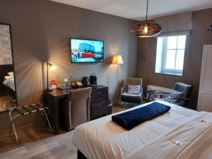 a bedroom with a bed and a desk and a tv at B&B Bloonwinning in Hasselt